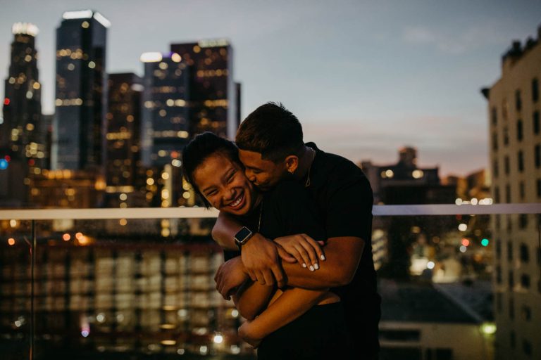 Freund küsst Freundin beim Paarshooting auf Dachterasse Gutschein