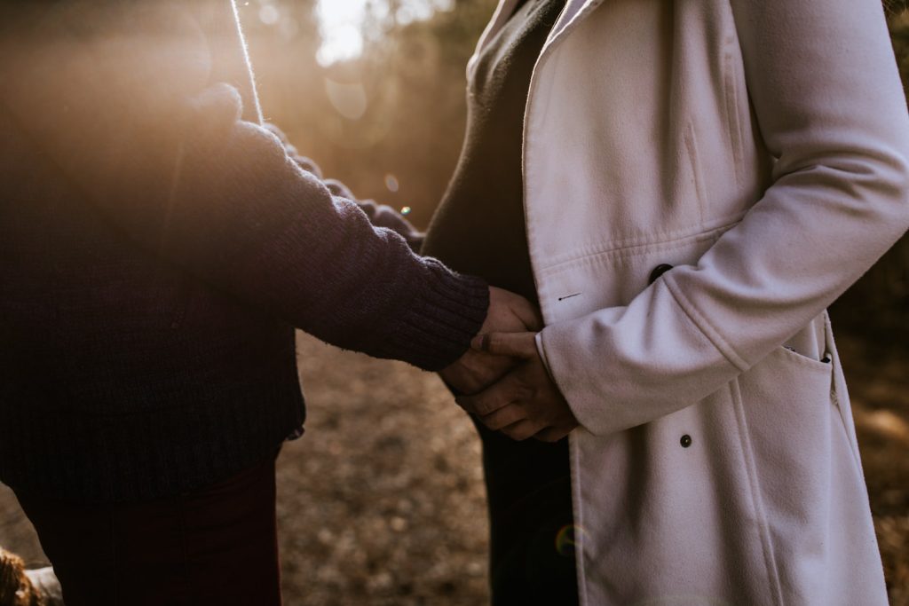 Goldene Stunde - Babybauchfotos - Mann hält Babybauch der Frau