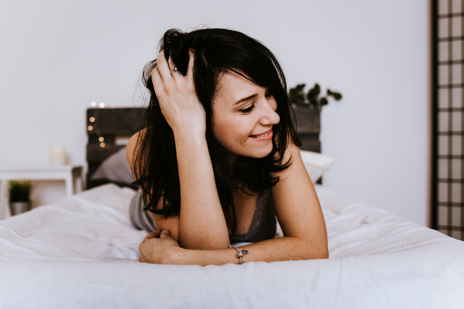 Boudoirfotografie aus Weilheim - Frau mit Händen in den Haaren auf einem Bett