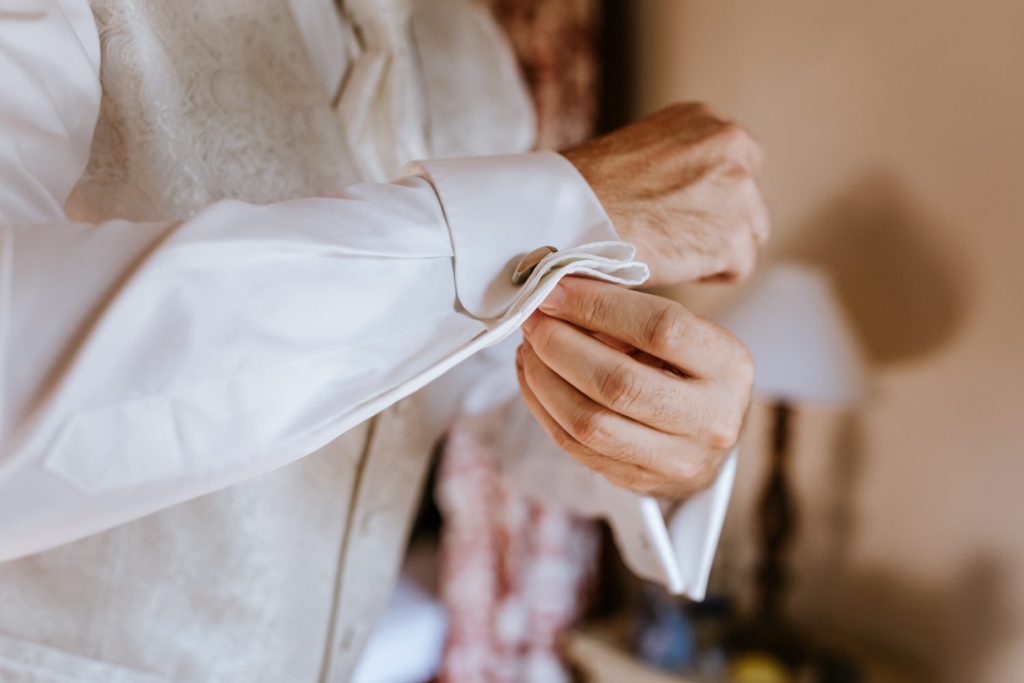 Getting Ready vom Bräutigam - Mann schließt die Manschettenknöpfe