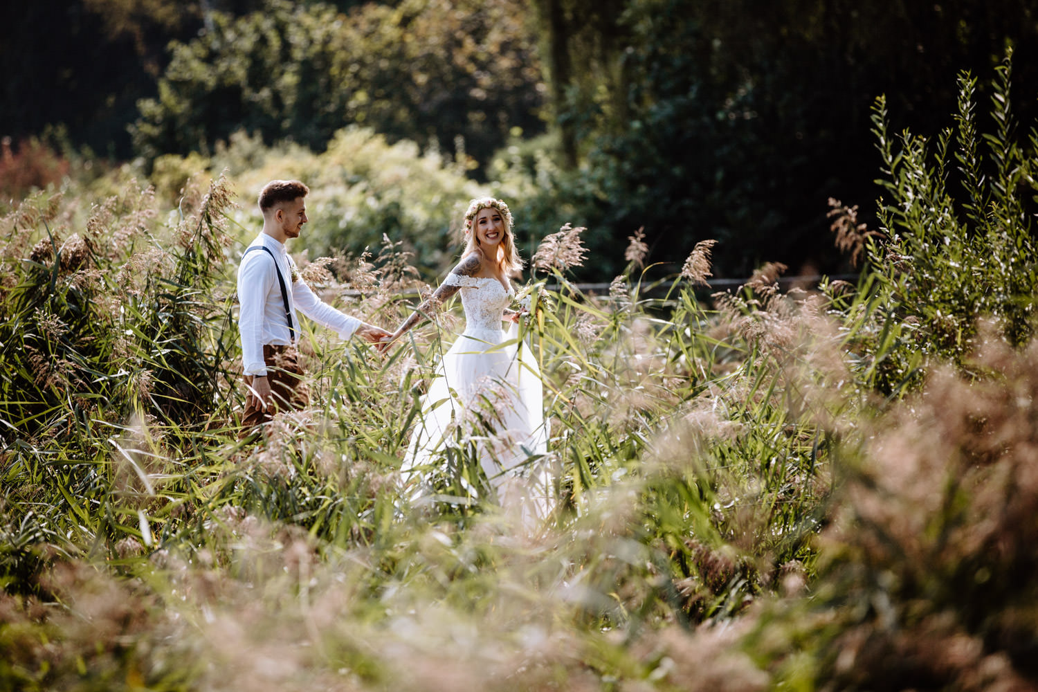 Braut und Bräutigam laufen durch ein Feld