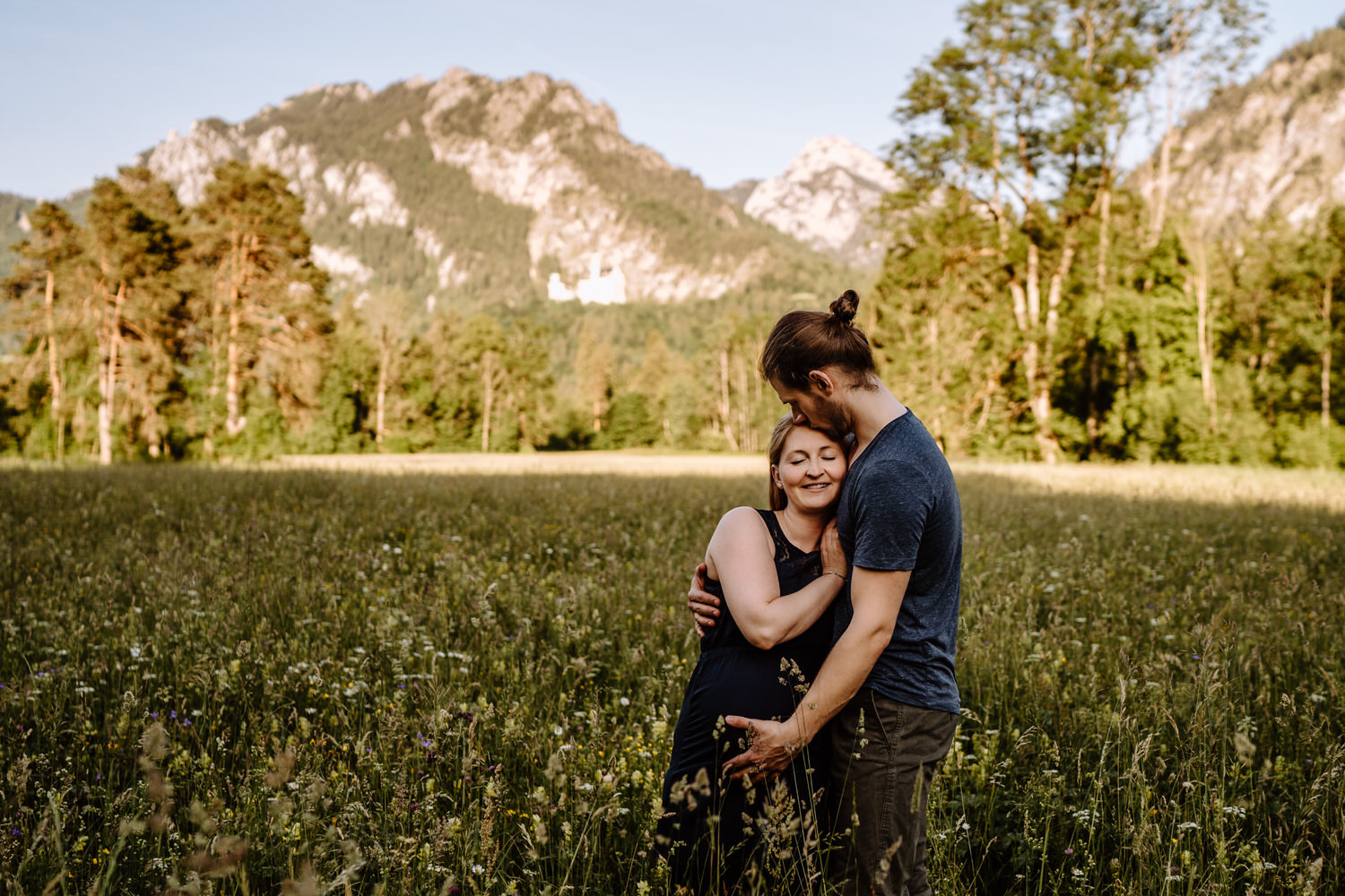 Babybauchfotos in der Natur mit Bergen im Hintergrund