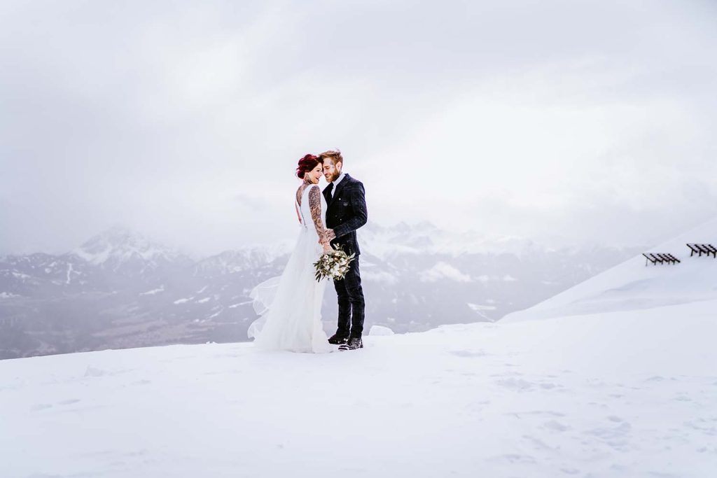 Wunderbare Hochzeitsfotos auf dem Berg mit Schnee in der Nähe von Innsbruck